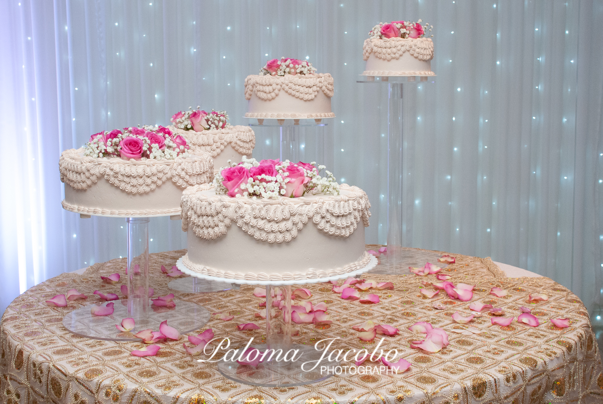 pasteles en pisos decorados con petalos de flores en fiesta de 15