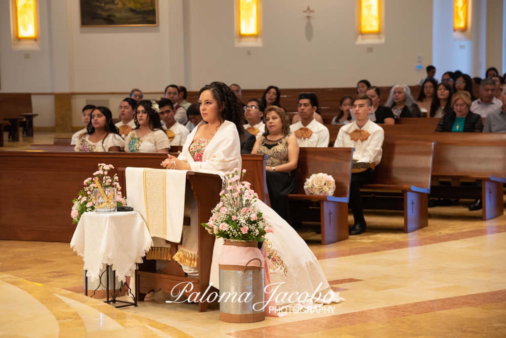 Quinceanera kneeling at church during mass