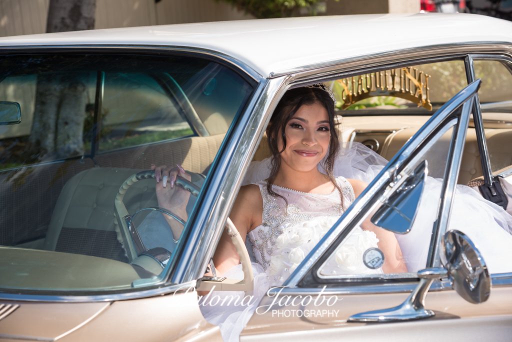 Quinceanera sitting down on an old school vintage classic car. San Diego Quinceanera Photography by Paloma Jacobo