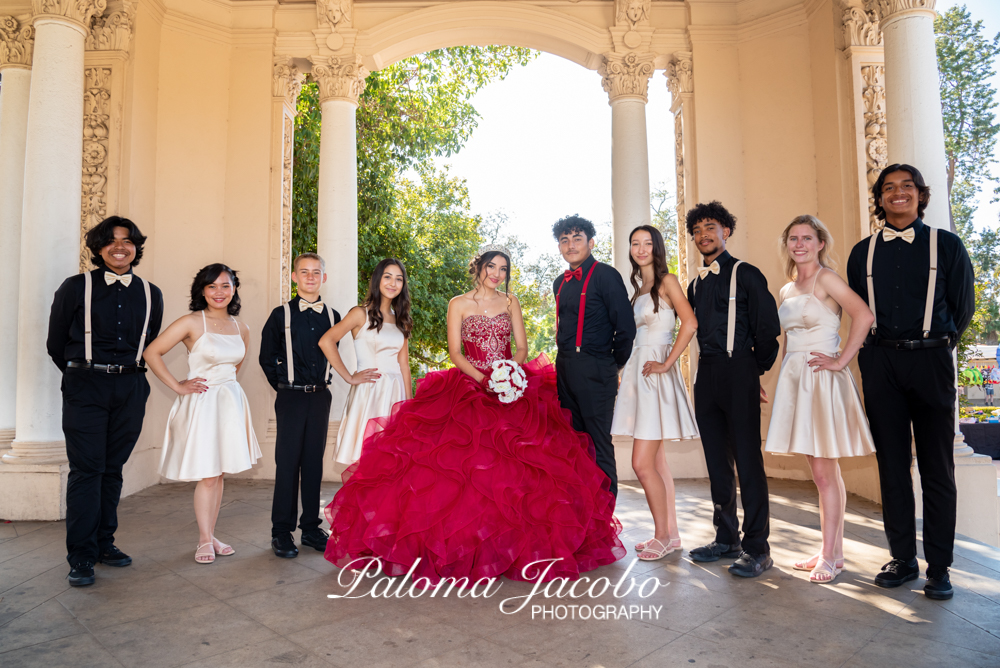 Quinceanera with her Damas and chambelanes posing for a picture at Balboa park
