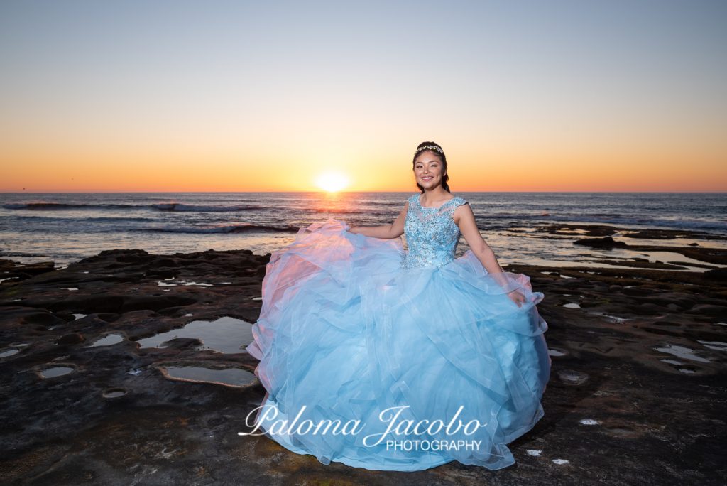 Quinceanera en sesion de fotos previa en el mar con el atardecer de fondo