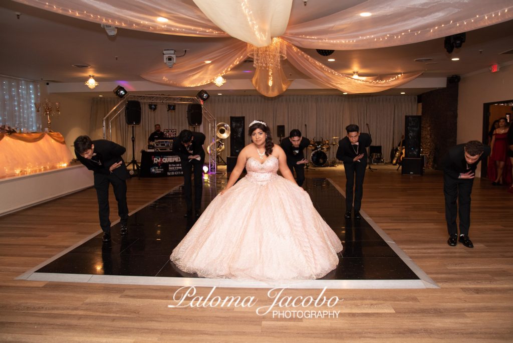 Quinceanera dancing her waltz with her chambelanes at her Quinceanera party