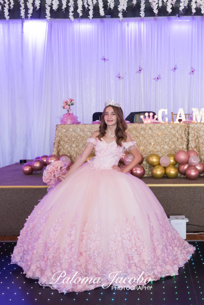 Quinceanera wearing a pink dress holding a pink flowers bouquet