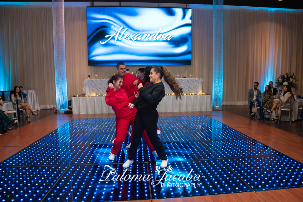 Quinceañera bailando el baile sorpresa con su corte de honor