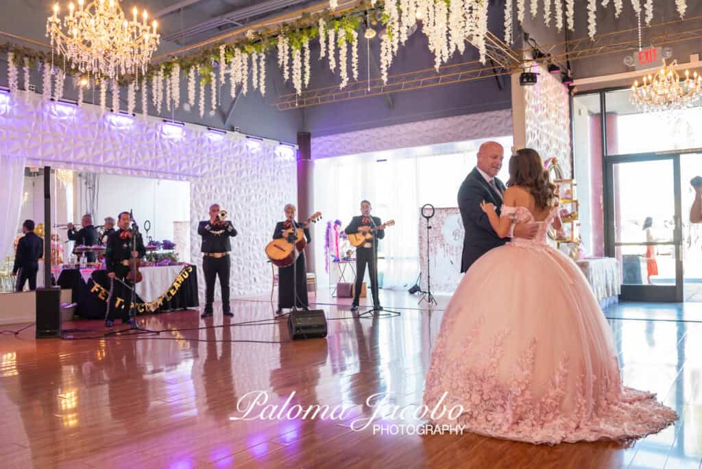 Mariachi playing while the Quinceanera dances with her dad