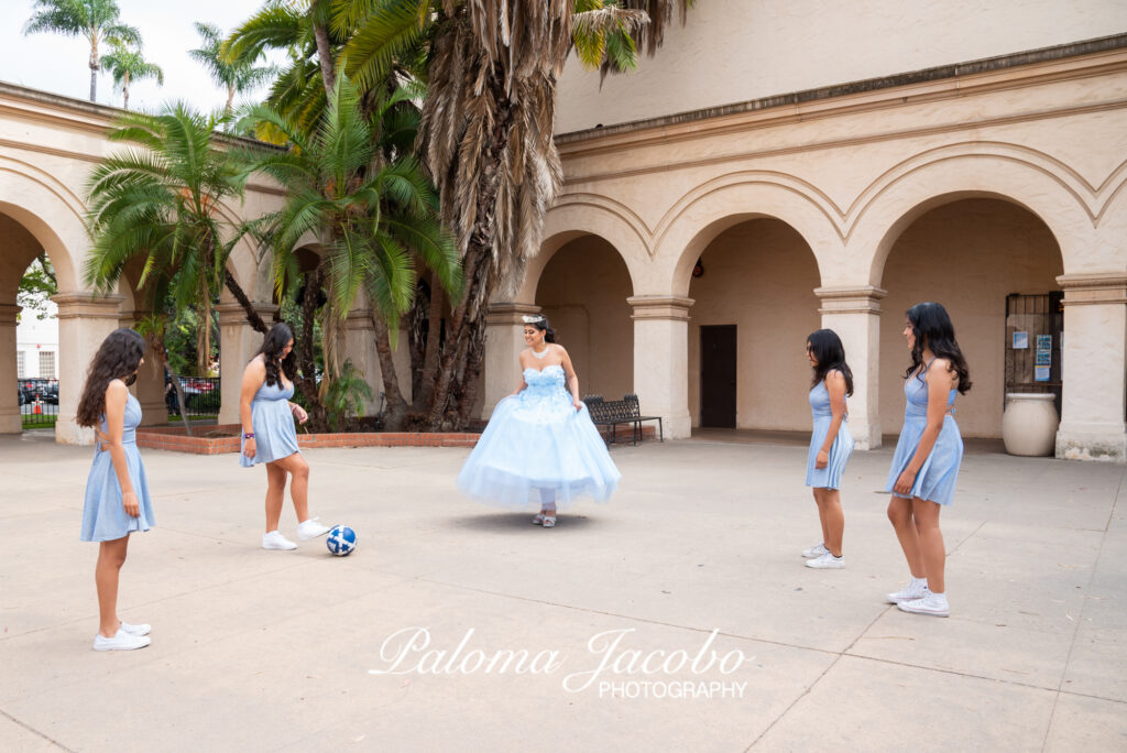 Quinceanera playing soccer with her damas during the photo shoot
