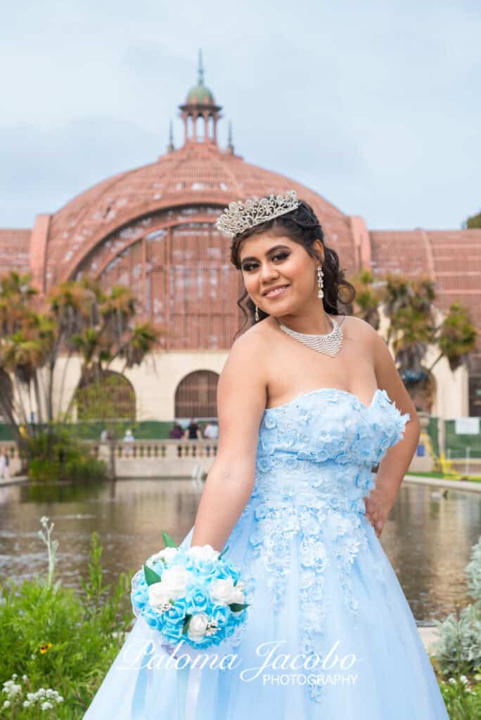 Quinceanera showing her dress by the lily pond in Balboa Park