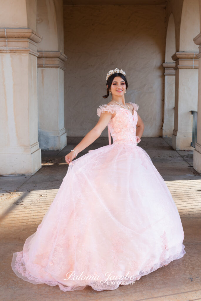 Quinceanera smiling at the camera while her picture is being taken 