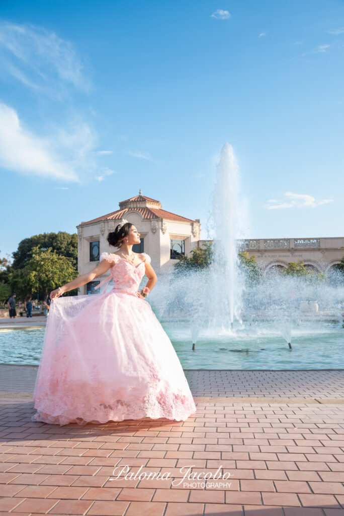 Quinceanera posing next to a fountain at Balboa Park