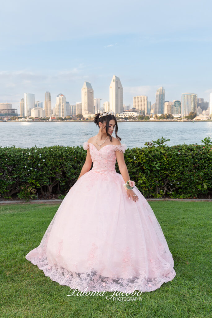 Quinceanera wearing an elegant pink dress with the city of San Diego on the background