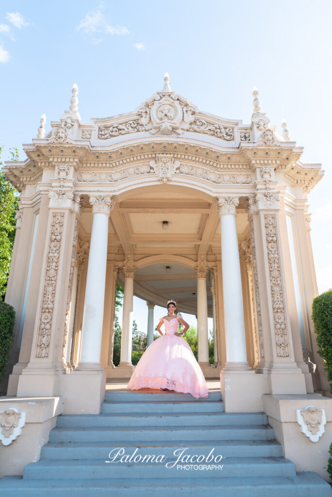 Quinceanera posing at the organ pavilion wearing an elegant pink dress