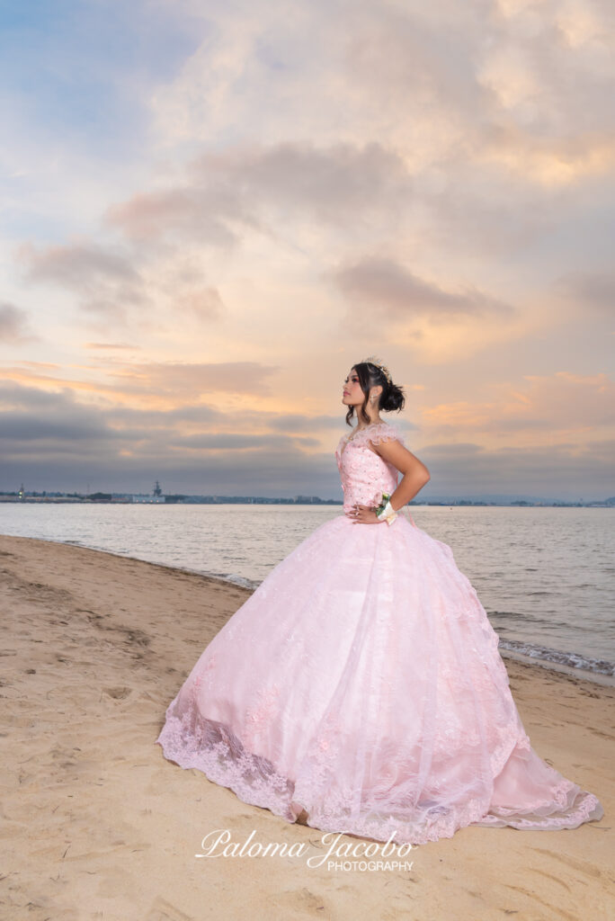 Quinceanera picture at the beach during sunset with an elegant pink dress